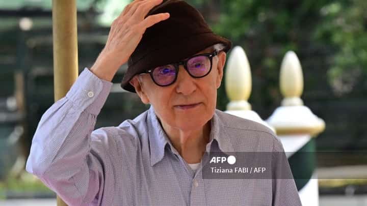 US director Woody Allen greets photographers as he arrives in taxi boat at the Excelsior Hotel on 4 September 2023 at Venice Lido to present his movie "Coup de Chance" at the 80th Venice Film Festival. (Photo by Tiziana FABI / AFP)