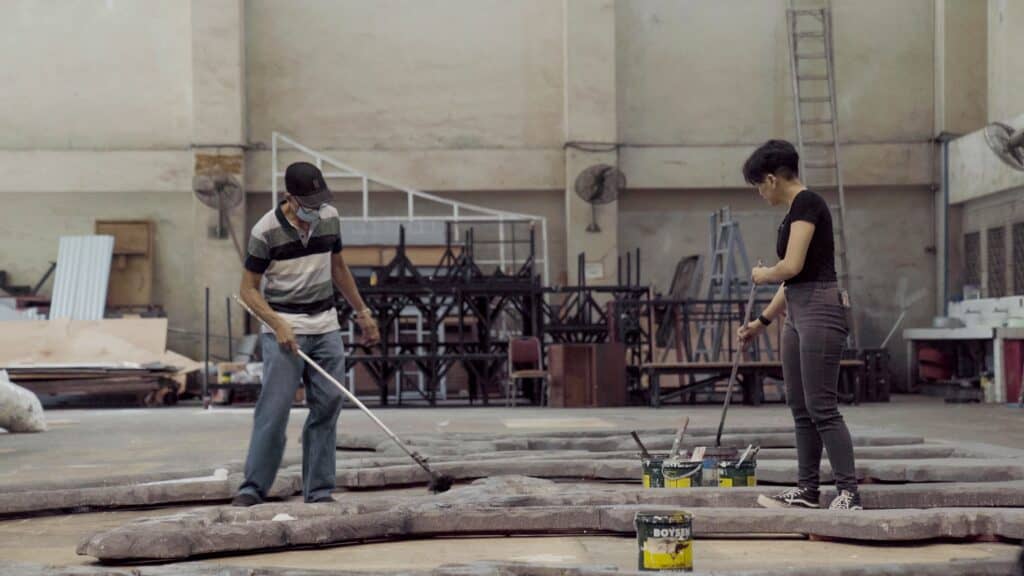 Francisco M. Galvero Jr., with his apprentice Annie Ignacio, preparing the set for a ballet production.