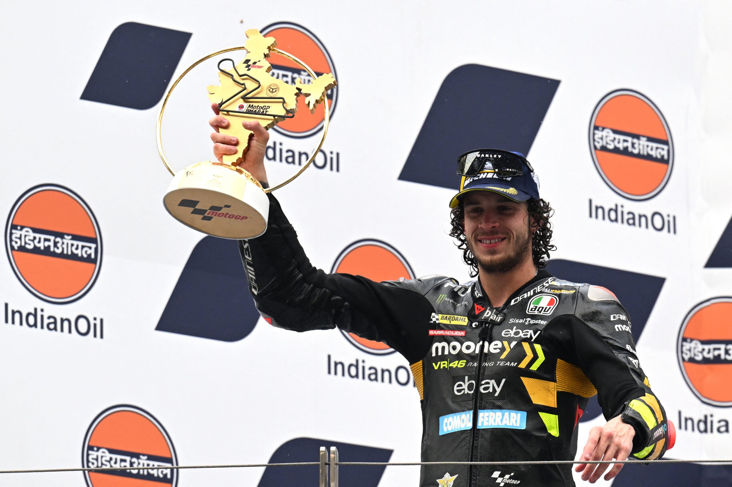 First placed Mooney VR46 Racing Team's Italian rider Marco Bezzecchi poses with the trophy on the podium after the Indian MotoGP Grand Prix at the Buddh International Circuit in Greater Noida on the outskirts of New Delhi, on 24 September 2023. (Photo by Money SHARMA / AFP)