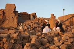 Afghan residents sit at a damaged house after earthquake in Sarbuland village of Zendeh Jan, district of Herat province, on October 7,2023 (Photo by Mohsen KARIMI / AFP)