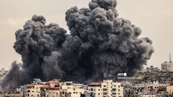 A plume of smoke rises in the sky of Gaza City during an Israeli airstrike on October 9, 2023. Israel relentlessly pounded the Gaza Strip overnight and into October 9 as fighting with Hamas continued around the Gaza Strip, as the death toll from the war against the Palestinian militants surged above 1,100. (Photo by MAHMUD HAMS / AFP)
