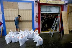 Shopkeepers take precautions by protecting store entrances with sandbags in Puerto Vallarta, Jalisco State, Mexico, on 10 October 2023, ahead of the arrival of Hurricane Lidia to Mexico's Pacific coast. 'Extremely dangerous' Hurricane Lidia makes landfall in Mexico according to the US National Hurricane Center. (Photo by Ulises RUIZ / AFP)