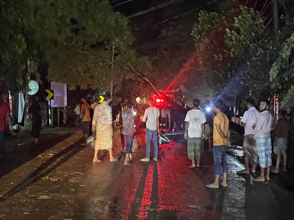 Bangladeshi men cut a fallen tree to clear a blocked road in Cox's Bazar in the early hours of 25 October 2023, after the landfall of cyclone Hamoon. Some 1,5 million people in Bangladesh were planned to evacuate ahead of the cyclone Hamoon forecasted to hit the region. (Photo by Tanbir MIRAJ / AFP)