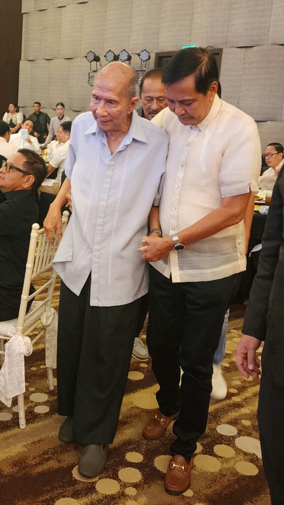 Cebu City Mayor Michael Rama assists awardee Monsignor Rodolfo Escalona Villanueva.