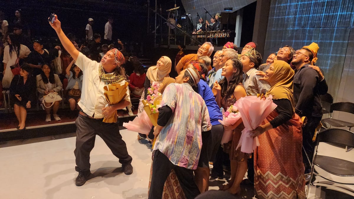 Artist Toym Imao taking a picture with the cast and creative team.
