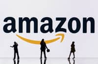 This illustration photograph taken on 30 October 2023, in Mulhouse, eastern France, shows figurines next to a screen displaying a logo of Amazon, a US multinational technology e-commerce company. (Photo by SEBASTIEN BOZON / AFP)