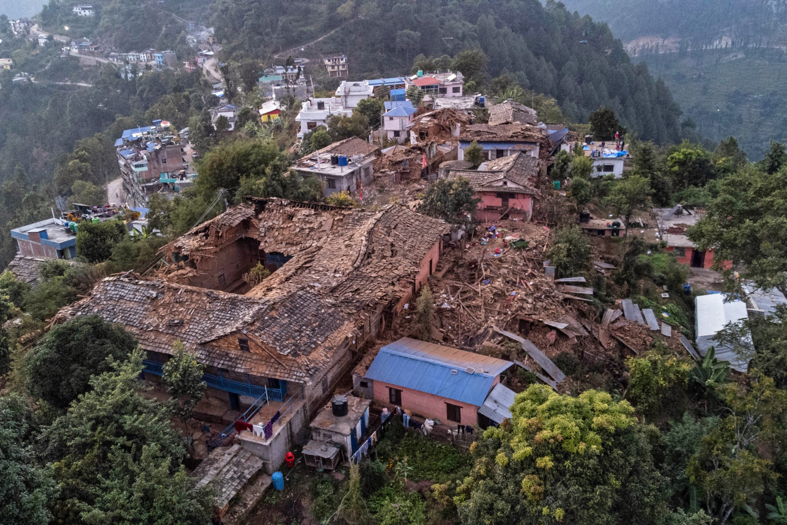An aerial view shows collapsed houses in the aftermath of an earthquake in Chiuri village at Jajarkot district on 5 November 2023. At least 157 people were killed in isolated western districts of the Himalayan country when the 5.6-magnitude earthquake hit late 3 November. (Photo by Prabin RANABHAT / AFP)