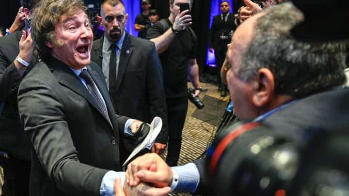 Argentine presidential candidate for the La Libertad Avanza alliance Javier Milei (L) celebrates with supporters after winning the presidential election runoff at his party headquarters in Buenos Aires on 19 November 2023. (Photo by LUIS ROBAYO / AFP)