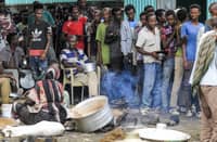FILE PHOTO: Ethiopian refugees of the Qemant ethnic group queue for food at a camp in the village of Basinga. (Photo by ASHRAF SHAZLY / AFP)