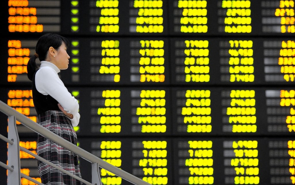 FILE PHOTO: A South Korean woman looks at a stock index board at the Korea Stock Exchange in Seoul. (Photo by JUNG YEON-JE / AFP)