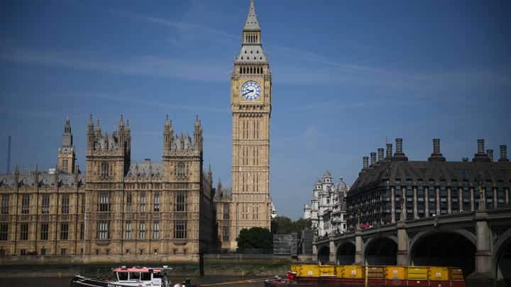 A tow boat goes past Palace of Westminster, home to the Houses of Parliament, and the Elizabeth Tower, commonly known by the name of the bell "Big Ben", in London on 15 June 2023. (Photo by Daniel LEAL / AFP)