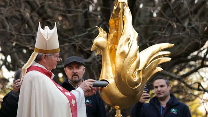 Archbishop of Paris Laurent Ulrich (L) places relics inside the new golden rooster during its blessing and prior to its installation atop the spire of Notre Dame cathedral as part of its reconstruction, in central Paris on 16 December 2023. (Photo by Thomas SAMSON / AFP)