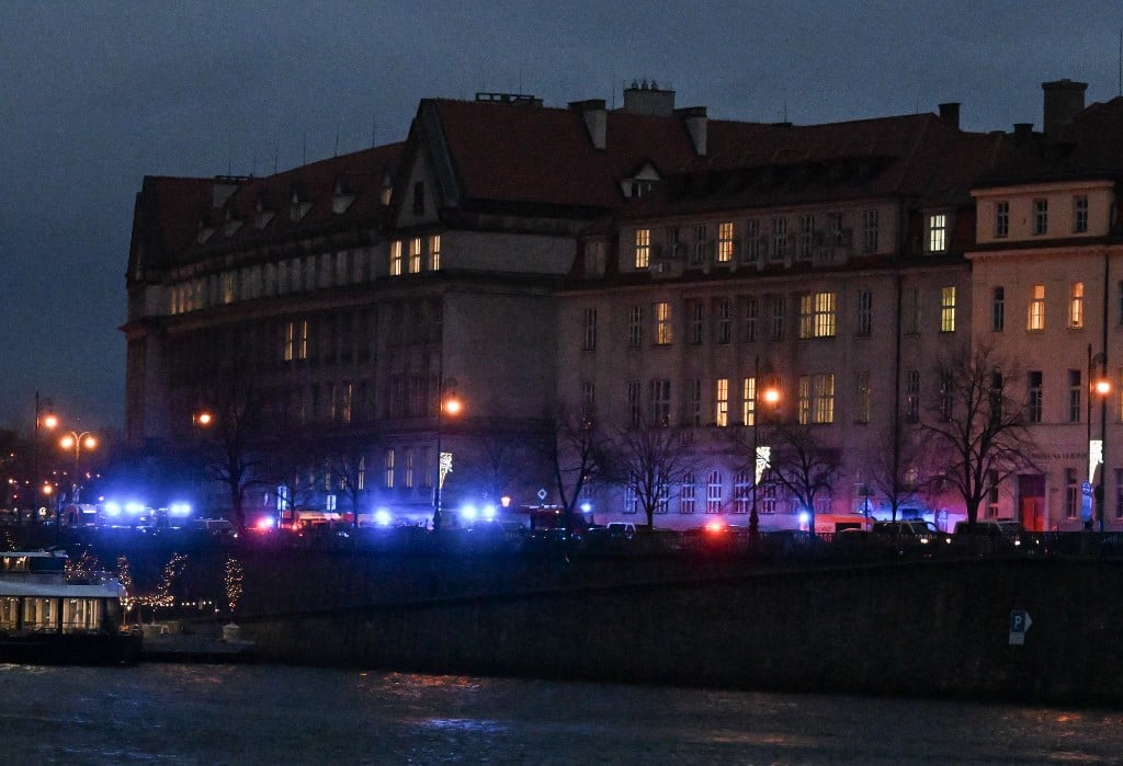 The flashing lights from emergency vehicles are seen along the bank of river Moldau by the Charles University in central Prague, on December 21, 2023. Czech police said a shooting in a university building in central Prague has left "dead and wounded people", without providing further details.
Photo by Michal CIZEK / AFP