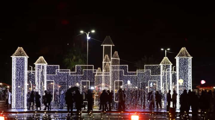 Syrians walk past Christmas decorations at a market in the capital Damascus on 23 December 2023. (Photo by LOUAI BESHARA / AFP)