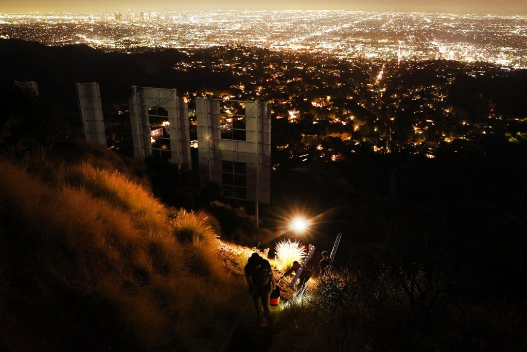 LOS ANGELES, CALIFORNIA - 08 DECEMBER: Equipment is carried away from the historic Hollywood sign on the 100th birthday of the iconic sign first being illuminated on 8 December 2023 in Los Angeles, California.  Mario Tama/Getty Images/AFP.