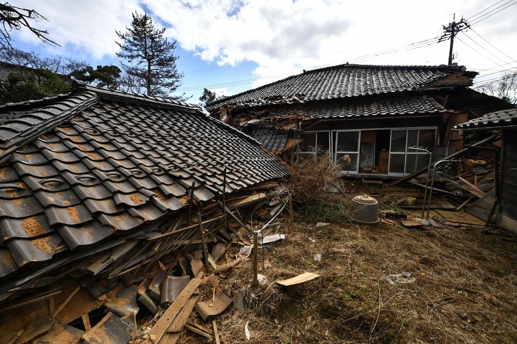 Collapsed wooden houses are seen in Shika Town, Ishikawa prefecture on 2 January 2024, a day after a major 7.5 magnitude earthquake struck the Noto region in Ishikawa prefecture in the afternoon. (Photo by Kazuhiro NOGI / AFP)