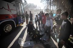 An injured man receives assistance after two explosions in quick succession struck a crowd marking the anniversary of the 2020 killing of Guards general Qasem Soleimani, near the Saheb al-Zaman Mosque in the southern Iranian city of Kerman on January 3, 2024. Photo by MEHR NEWS / AFP