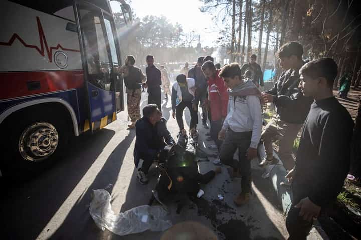 An injured man receives assistance after two explosions in quick succession struck a crowd marking the anniversary of the 2020 killing of Guards general Qasem Soleimani, near the Saheb al-Zaman Mosque in the southern Iranian city of Kerman on January 3, 2024. Photo by MEHR NEWS / AFP
