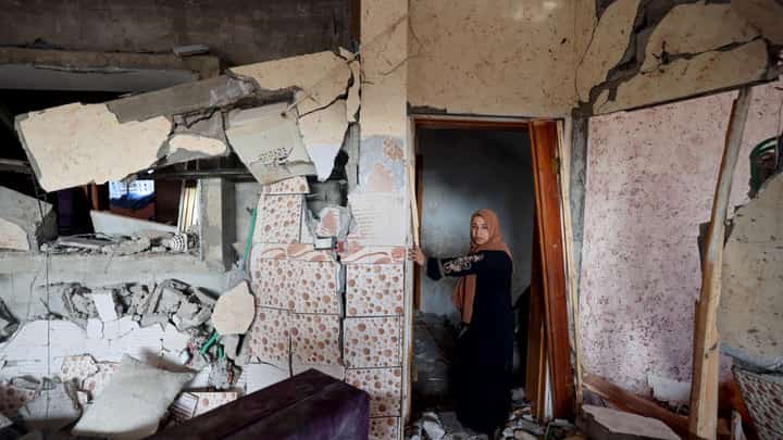 A woman stands in her damaged house in Rafah, on the southern Gaza Strip on January 5, 2024, following Israeli bombardment amid continuing battles between Israel and the Palestinian militant group Hamas. (Photo by AFP)