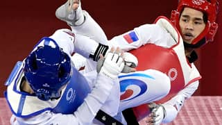 South Korea's Jang Jun (Blue) and Philippines' Kurt Bryan Barbosa (Red) compete in the taekwondo men's -58kg elimination round bout during the Tokyo 2020 Olympic Games at the Makuhari Messe Hall in Tokyo on July 24, 2021.