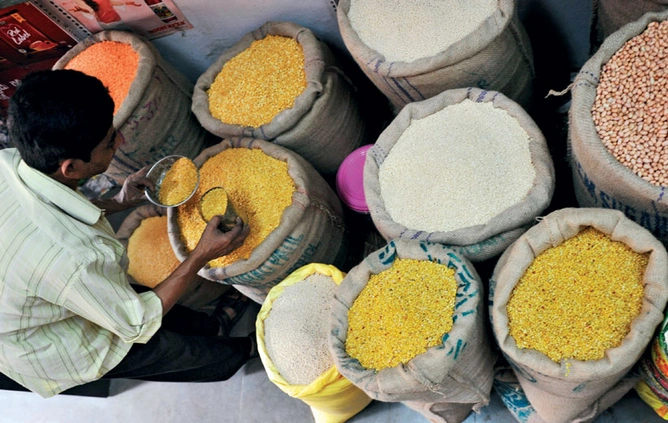 A trader samples varieties of pulses at a mandi in Hyderabad. Farmers apart,<br />
Tata Chem also sources its supply from the local market.