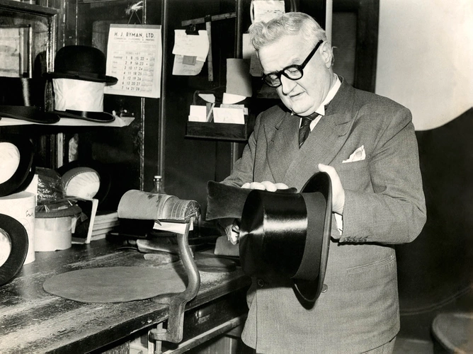 A hatter from Lock &amp; Co. in the process of polishing a silk top hat in this undated photo from the store. &nbsp;