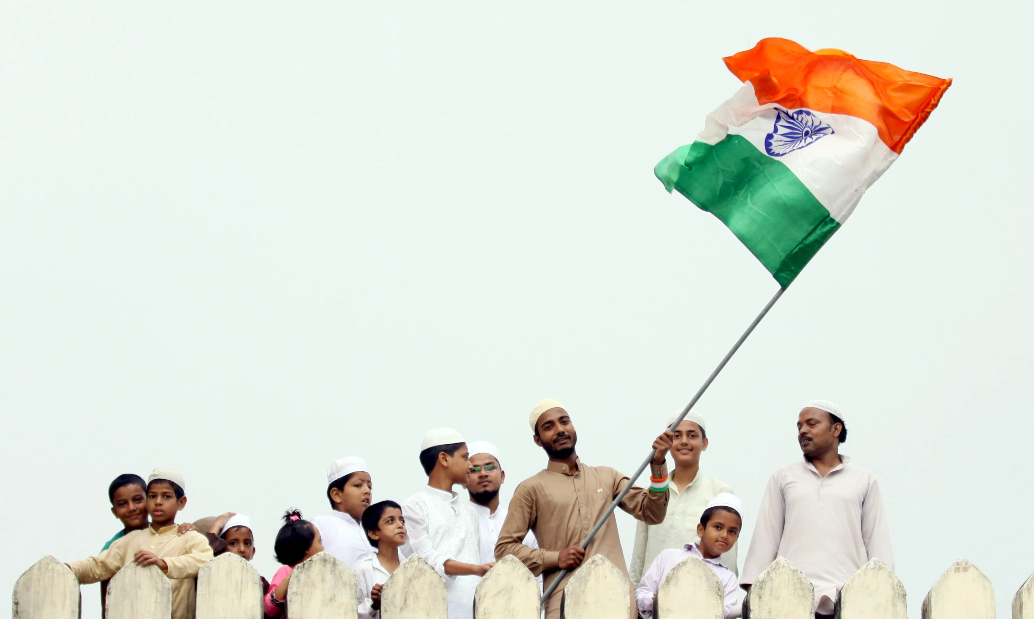 Students of Darul Uloom Nadwatul Ulama institution wave National flag on the occasion of Independence Day celebration at a college campus in Lucknow