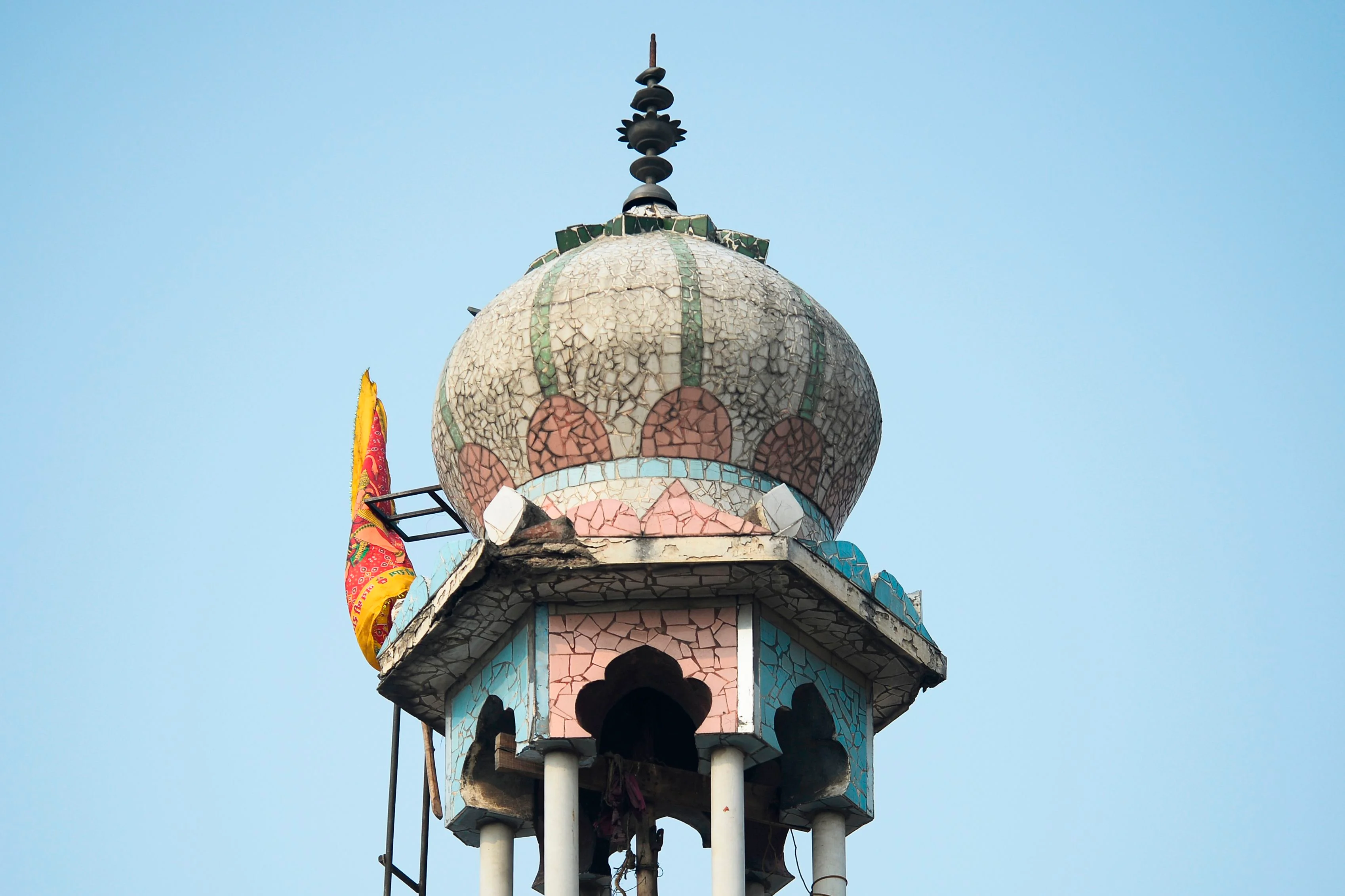 A Hindu religious flag is seen on a minaret of a burnt-out mosque following clashes between people supporting and opposing a contentious amendment to India's citizenship law, in New Delhi on February 26, 2020.