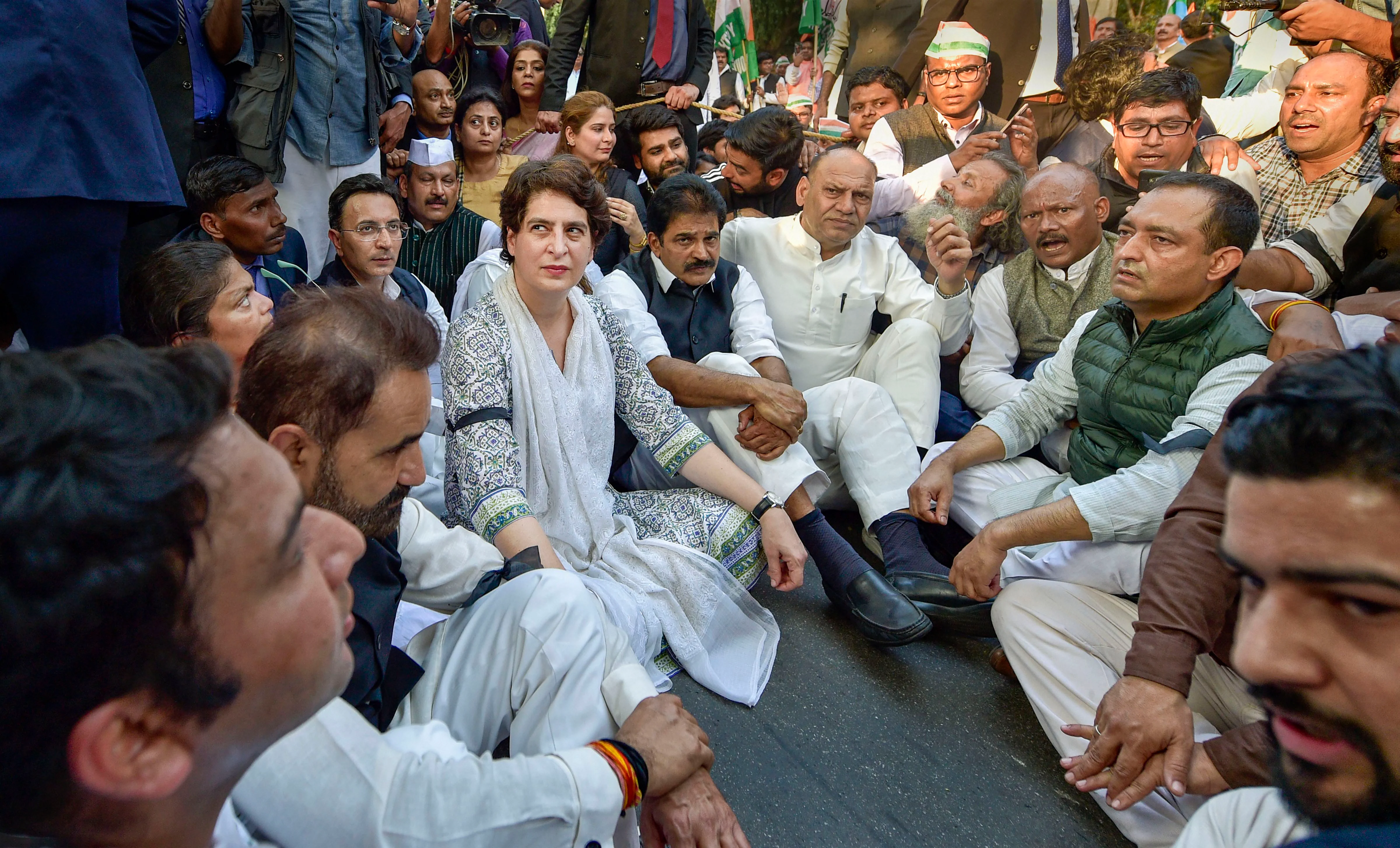 AICC General Secretary Priyanka Gandhi Vadra along with party workers sits on a street after being stopped by police officials during a peace march from AICC Headquarters to 30 January Marg against the communal violence in North-East Delhi area, in New Delhi on Wednesday.