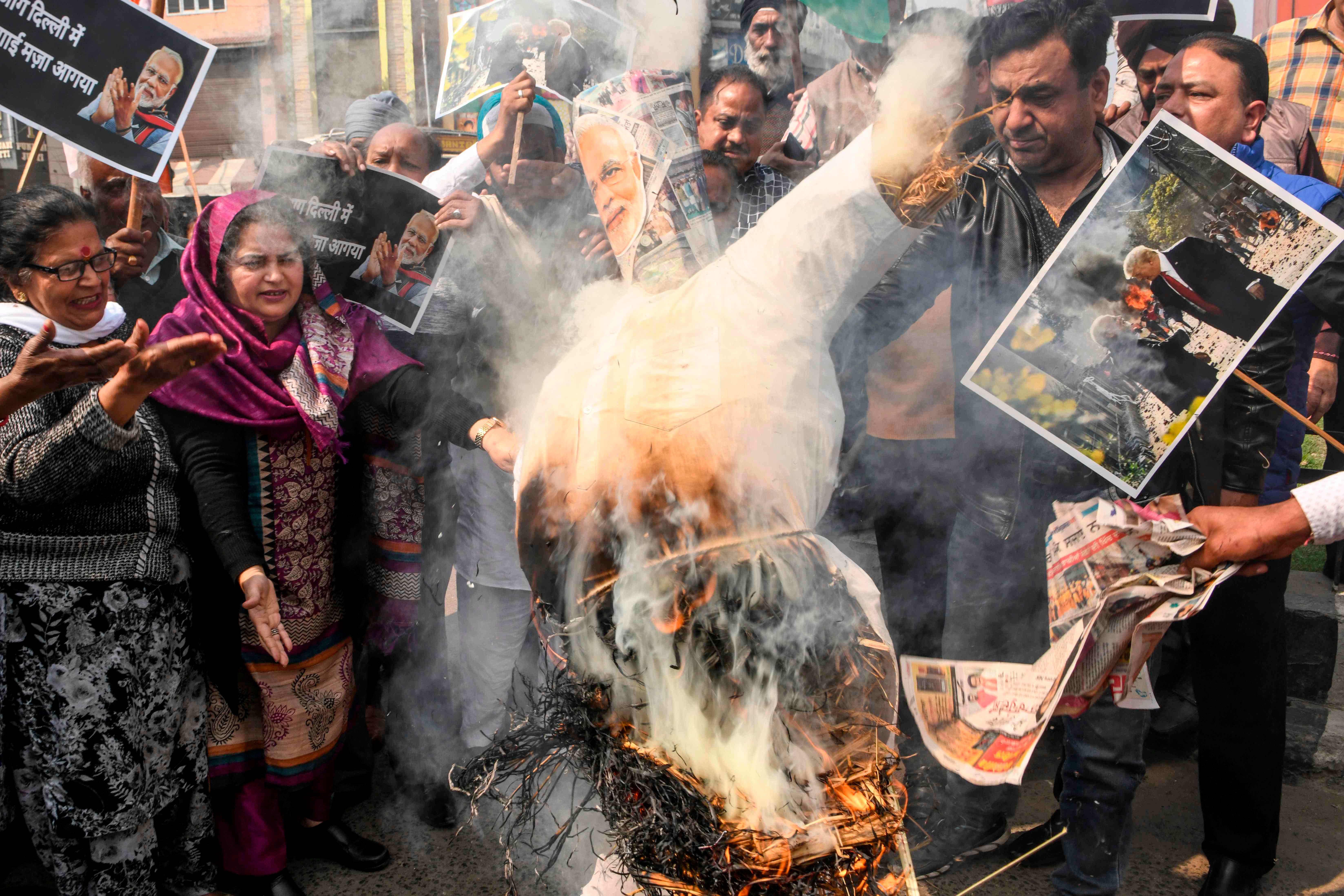 Congress Party workers shout slogans as they burn an effigy of India's Prime Minister Narendra Modi during a demonstration to protest against the violence occurring in New Delhi, in Amritsar on February 26, 2020