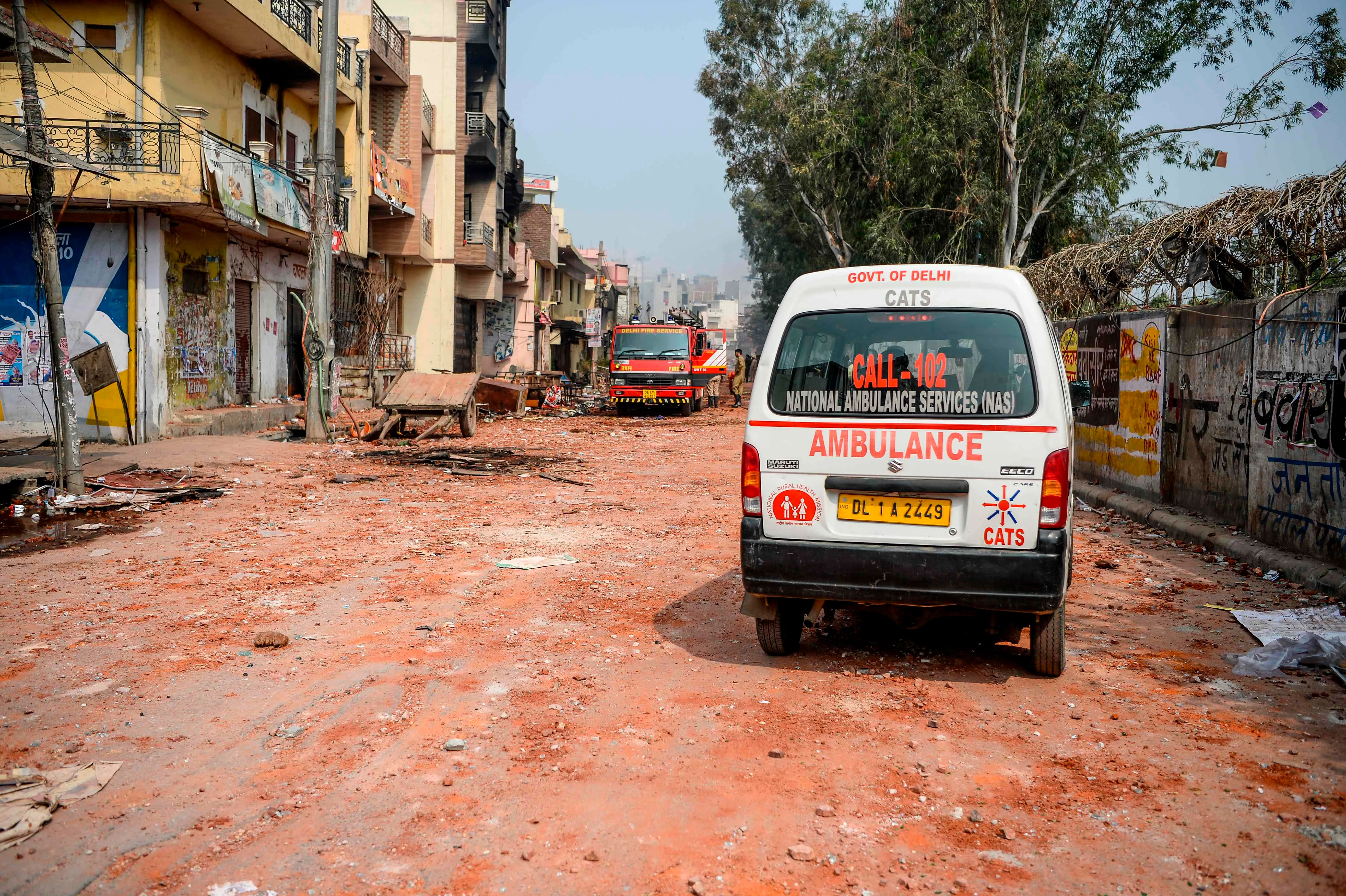 A firefighter vehicle and an ambulance are parked near burnt-out and damaged premises following clashes between people supporting and opposing a contentious amendment to India's citizenship law, in New Delhi on February 26, 2020
