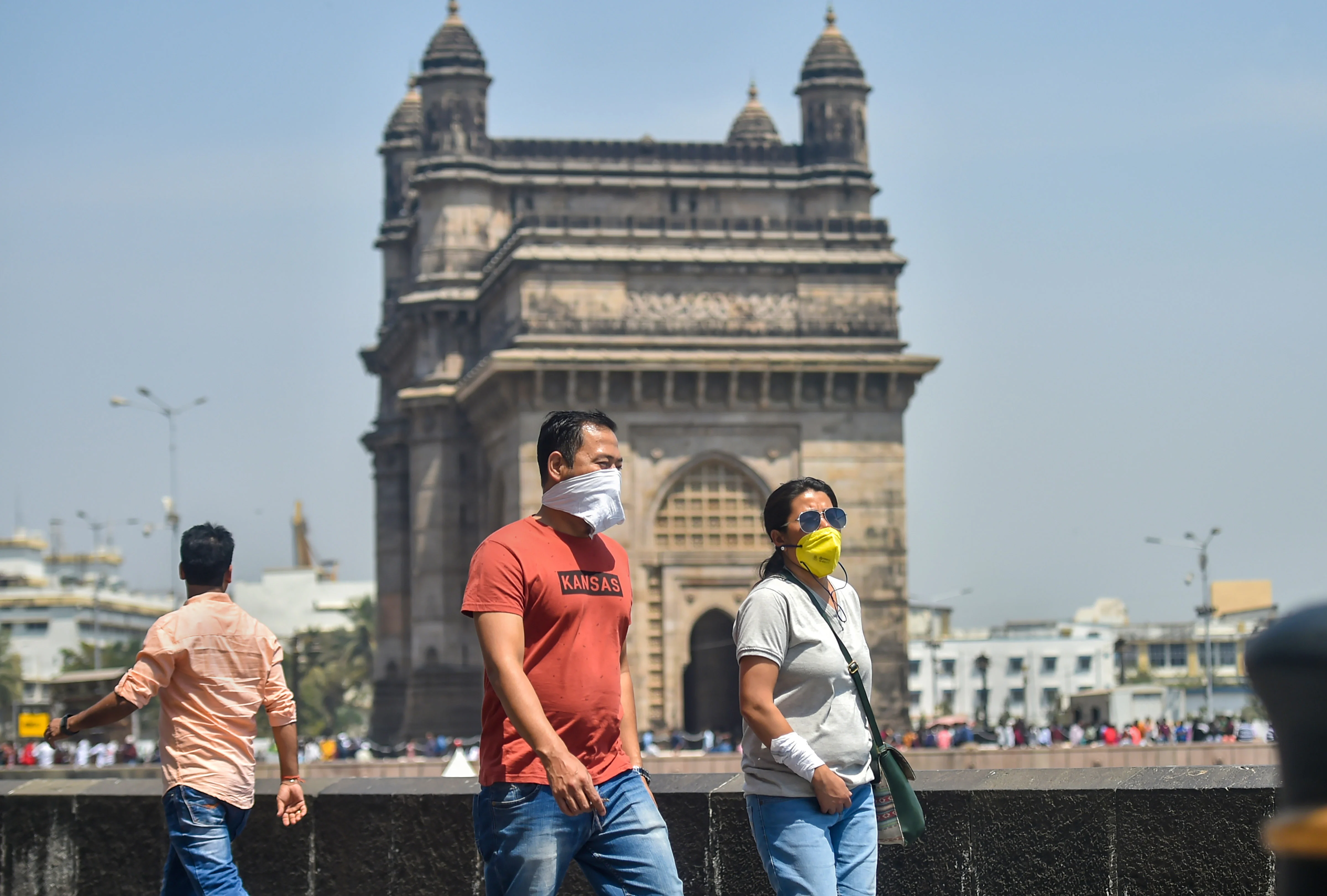 Tourists wear protective masks in view of coronavirus pandemic at Gateway of India in Mumbai
