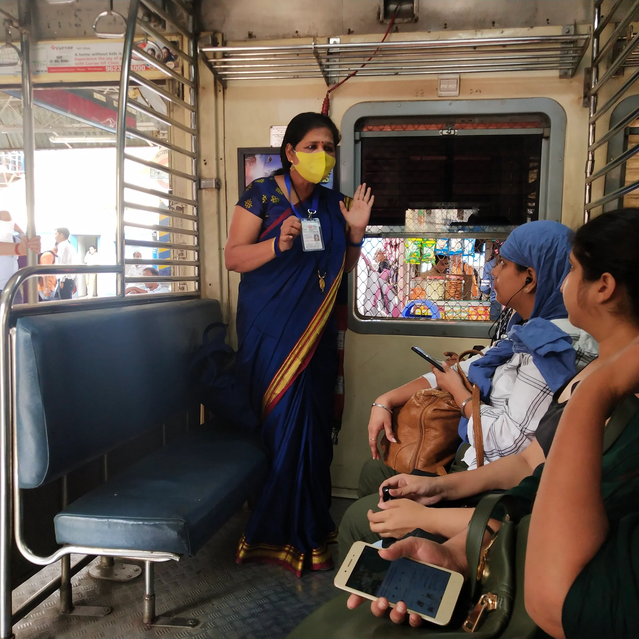Central Railway staffer instructing passengers to to use the mask