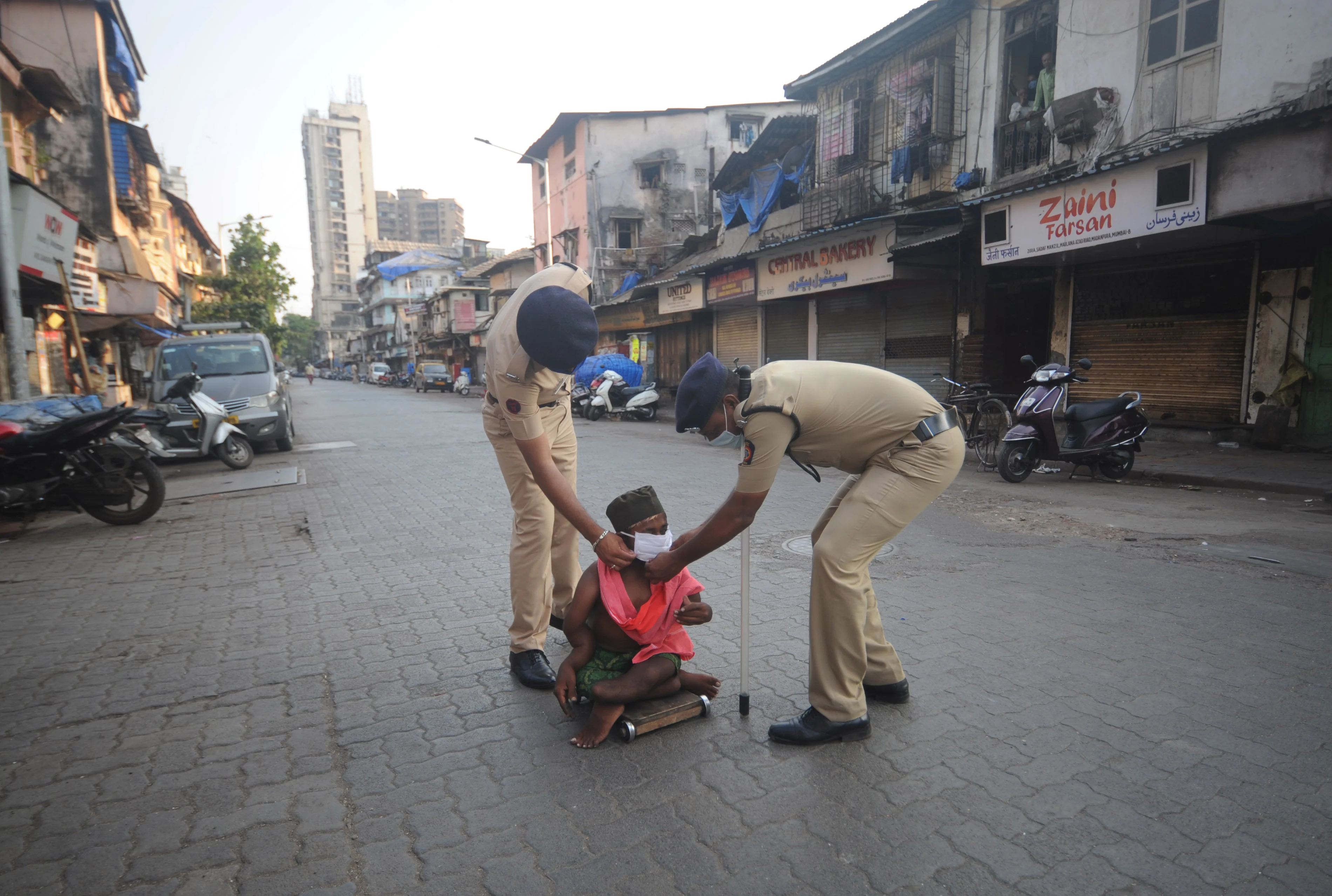 Policemen help a disabled person to wear a mask amid coronavirus pandemic