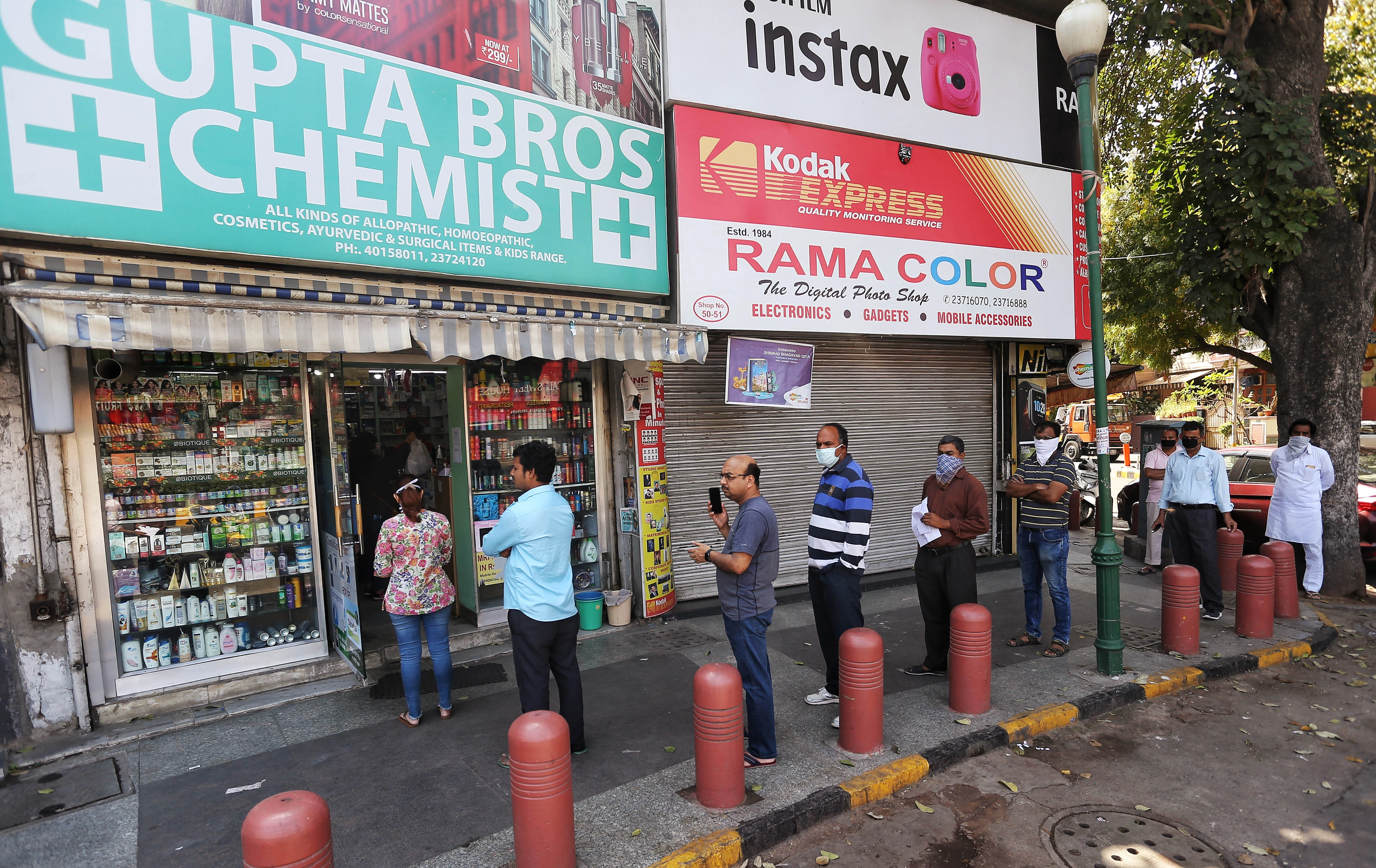 Social distancing was seen as people standing in a queue outside a medical store at Bengali Market in New Delhi on Wednesday.