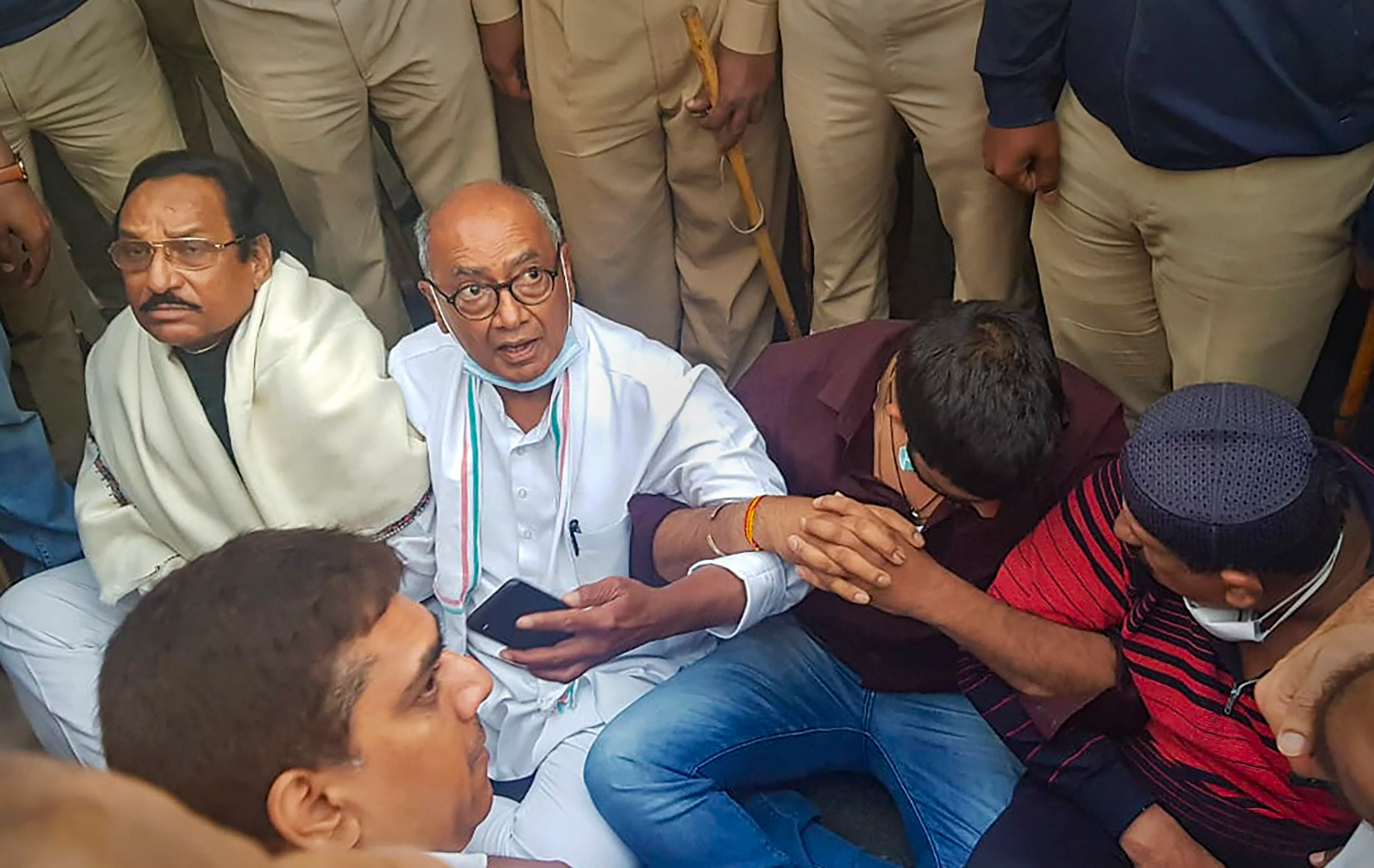 Congress leader Digvijaya Singh sits on a dharna near Ramada hotel after he was allegedly not allowed by police to visit Madhya Pradesh Congress MLAs lodged at the hotel, in Bengaluru.