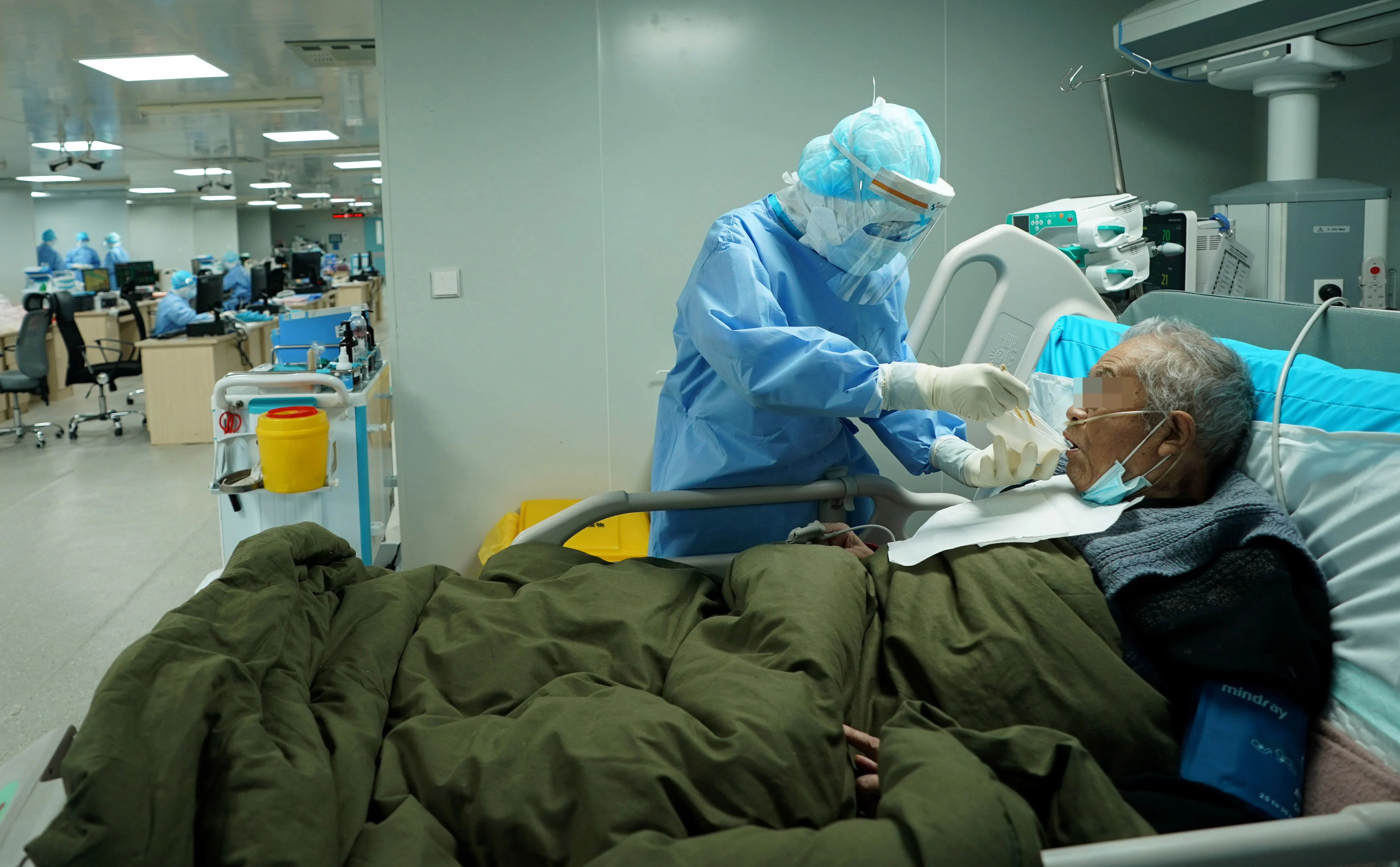 A nurse of the ICU (intensive care unit) feeds meal to a COVID-19 patient in severe condition at the Huoshenshan (Fire God Mountain) Hospital in Wuhan, central China's Hubei Province, March 17, 2020.