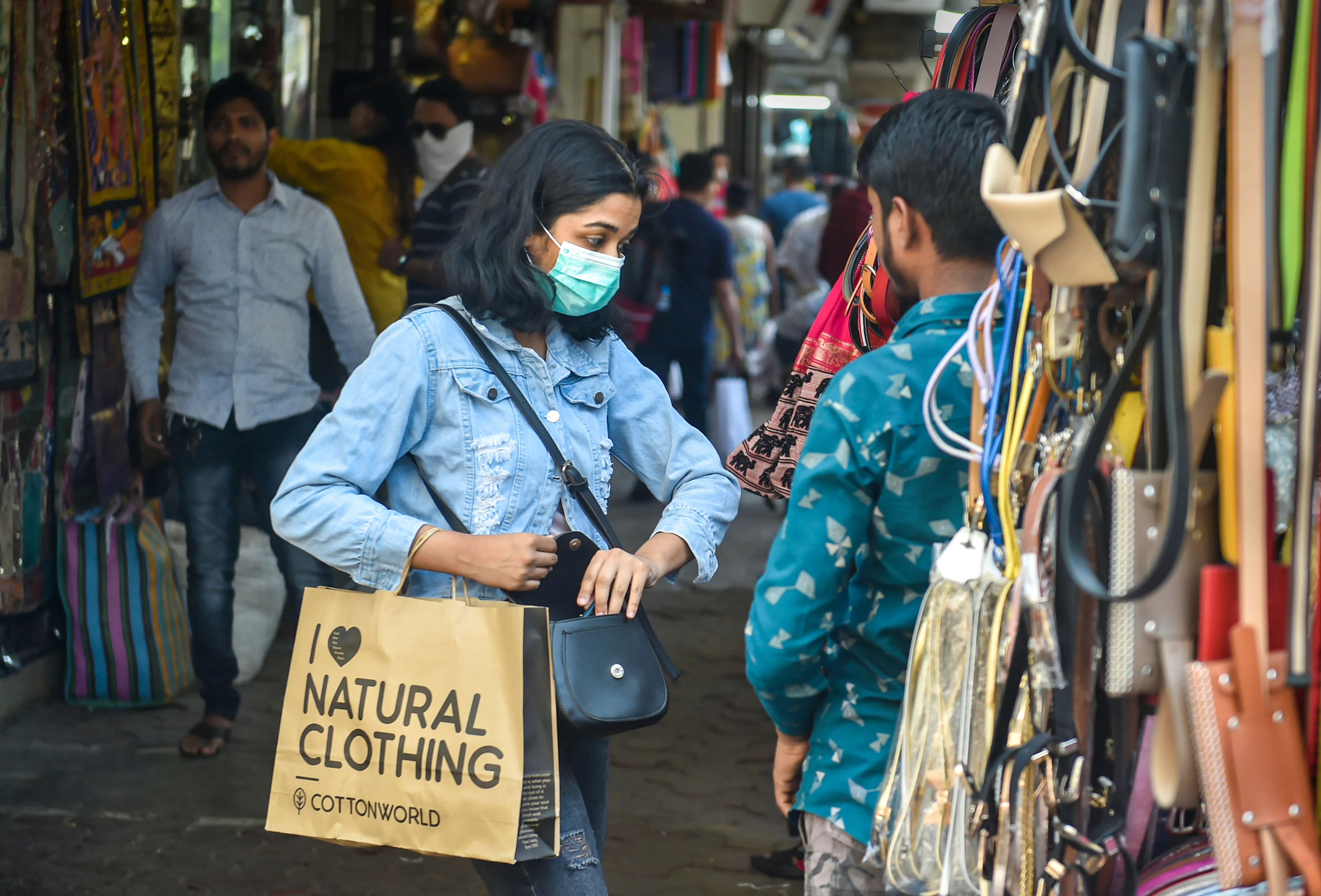 A woman wears a protective mask, in view of coronavirus pandemic, as she shops at Colaba Causeway Market in Mumbai