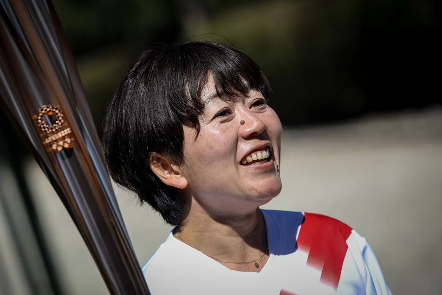 The second torchbearer Mizuki Noguchi, gold medalist in the women's marathon at the 2004 Athens Olympics, holds the torch after the flame lighting ceremony for Tokyo 2020 Olympic Games in Olympia, Greece, March 12, 2020.