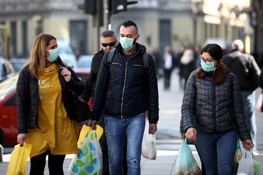 People wearing masks walk on a street in Sarajevo, Bosnia and Herzegovina (BiH) on March 18, 2020.