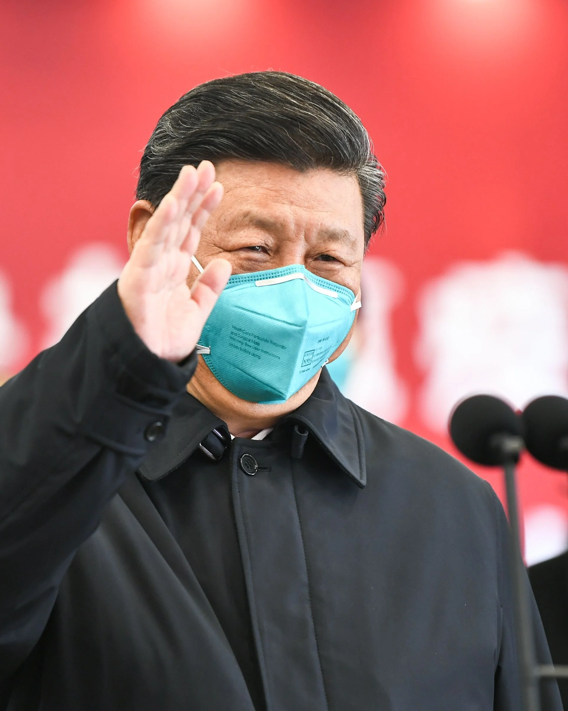Xi Jinping waves to a coronavirus patient and medical staff via a video link at the Huoshenshan hospital in Wuhan on March 10, 2020
