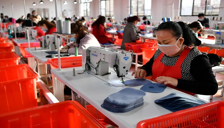 Workers manufacture suitcases at a factory in Yaozhou District of Tongchuan City, northwest China's Shaanxi Province, March 12, 2020.
