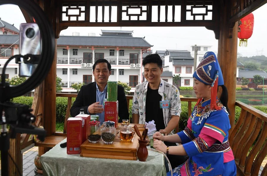 Residents from Shanglin county in southern China's Guangxi Zhuang Autonomous Region talk about local farm goods during a livestreaming activity on March 24, 2020.