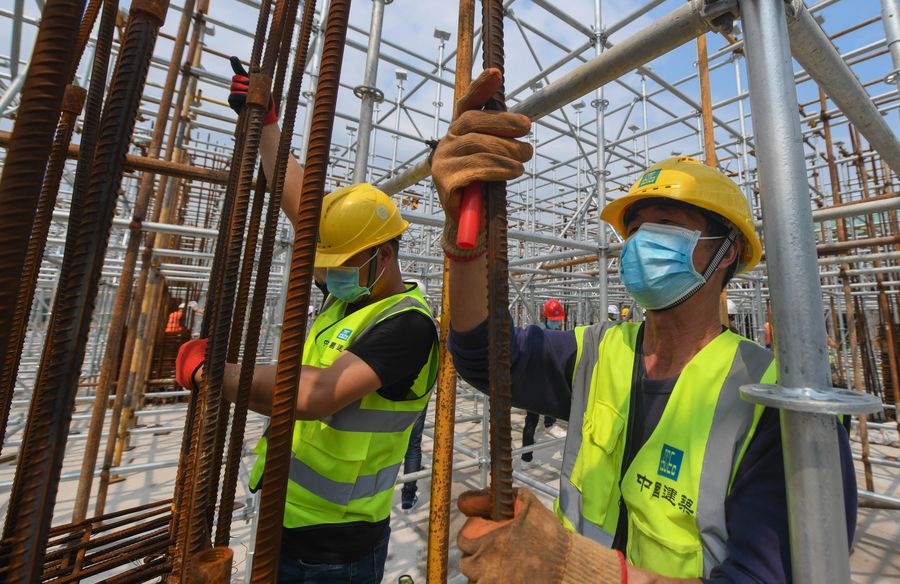 Staff members work at a construction site in Wuhan, central China's Hubei Province, March 26, 2020.