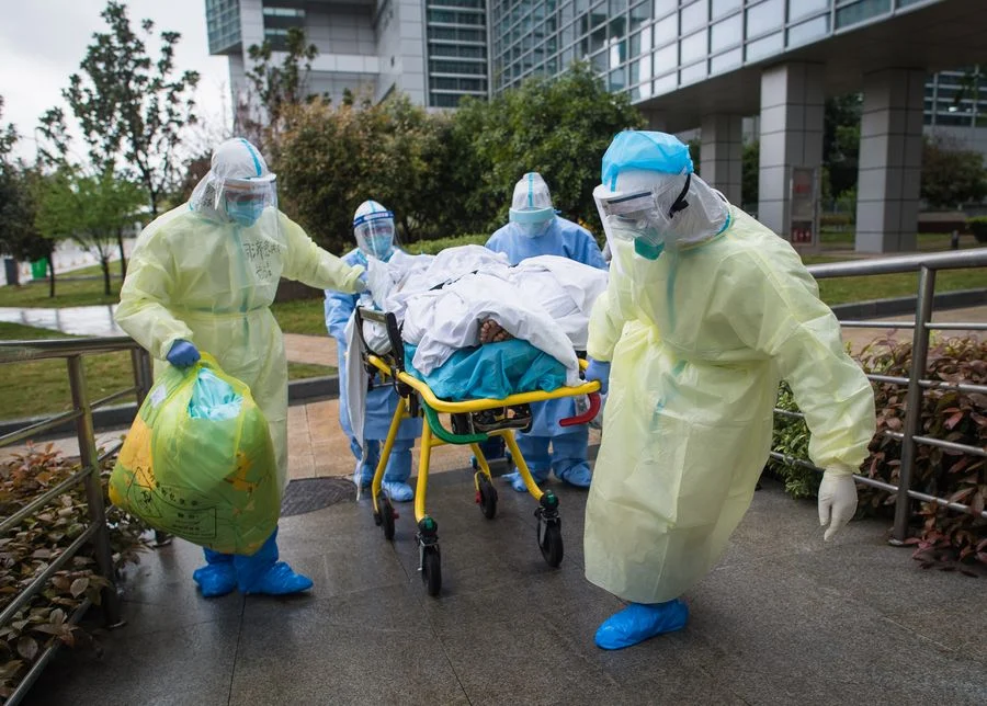 Medical workers wheel a patient to the Zhongfaxincheng campus of Tongji Hospital affiliated to Huazhong University of Science and Technology in Wuhan, central China, March 29, 2020.