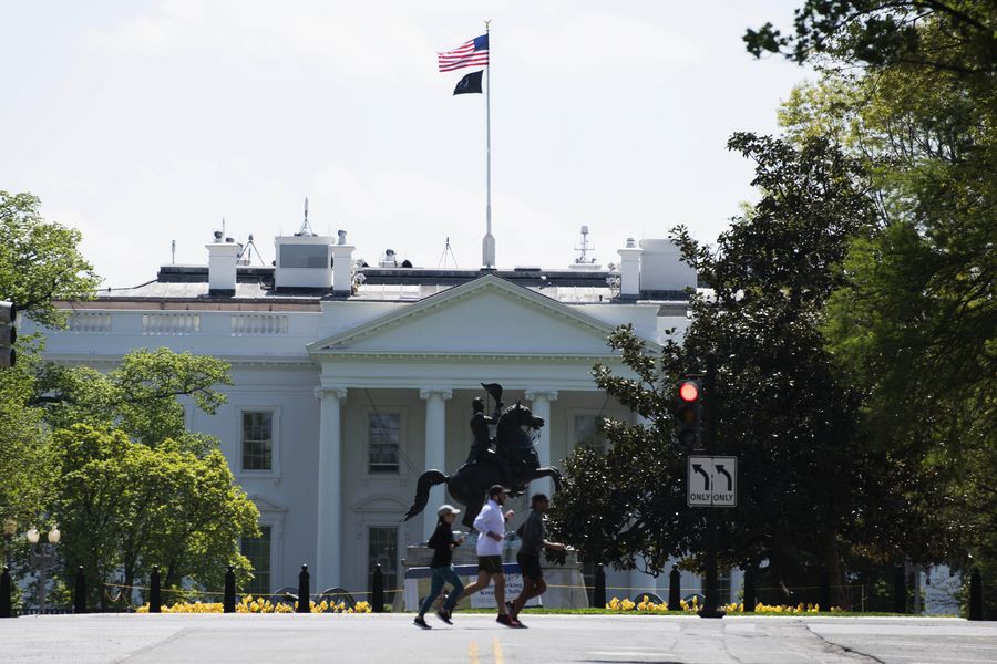 People jog near the White House in Washington D.C., the United States, on April 16, 2020.