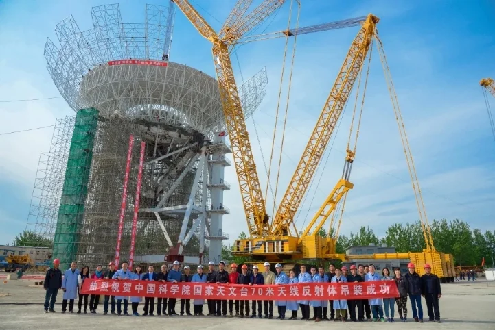 Scientists and workers pose for a photo after the antenna installation at the construction site of the steerable radio telescope in Wuqing District of northern China's Tianjin.