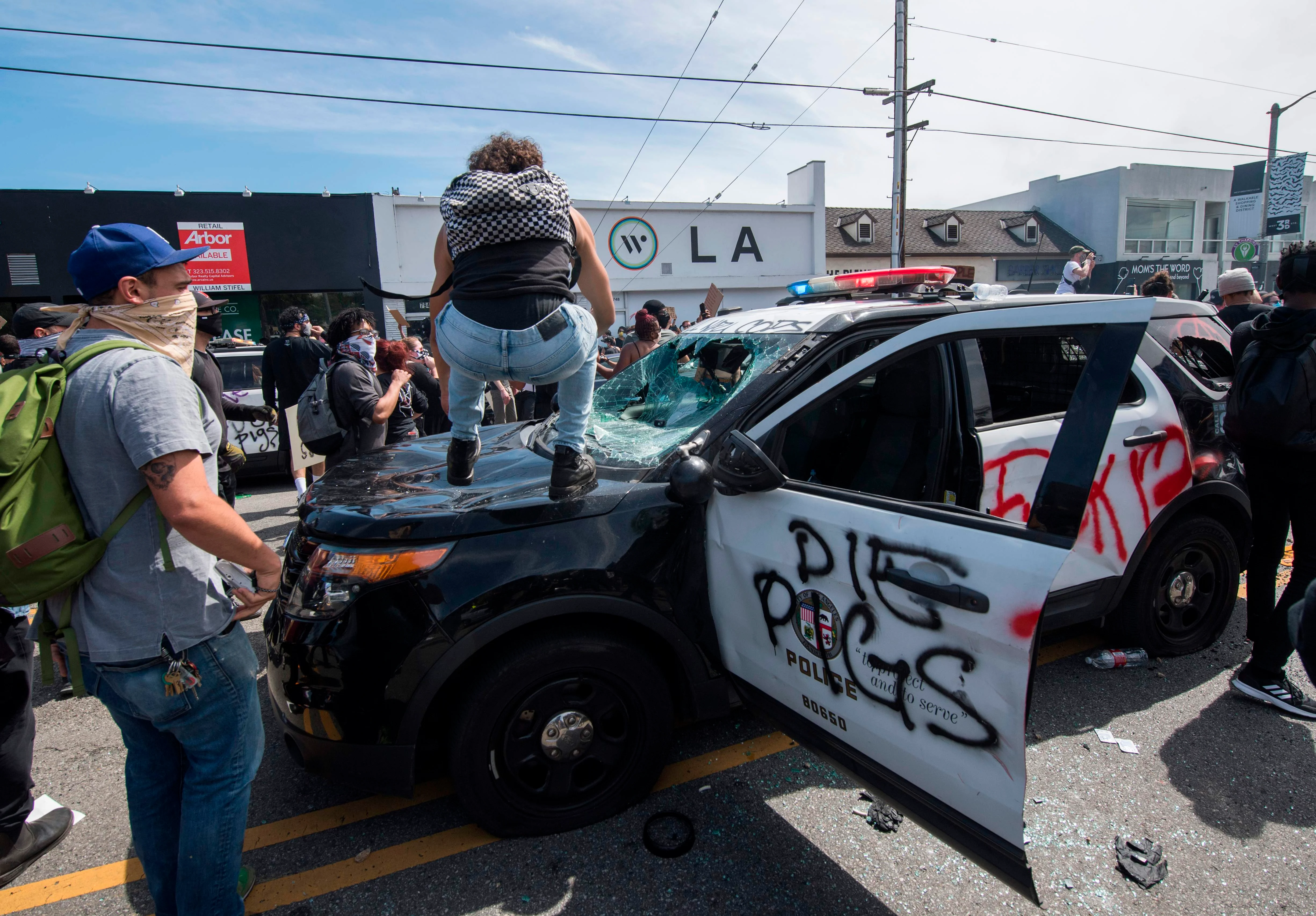Protestors vandalise a police car in the United States