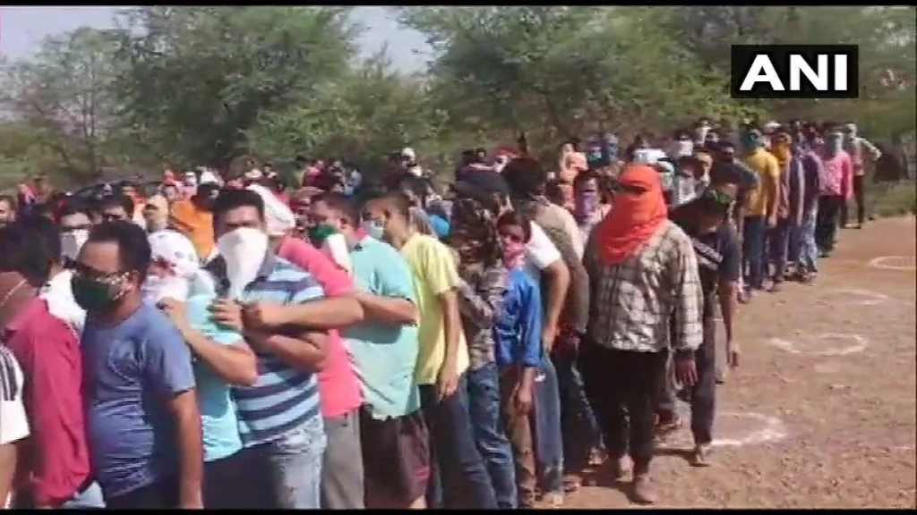 Social distancing norms being flouted as people in large numbers queue outside a liquor shop in Rajnandgaon. T