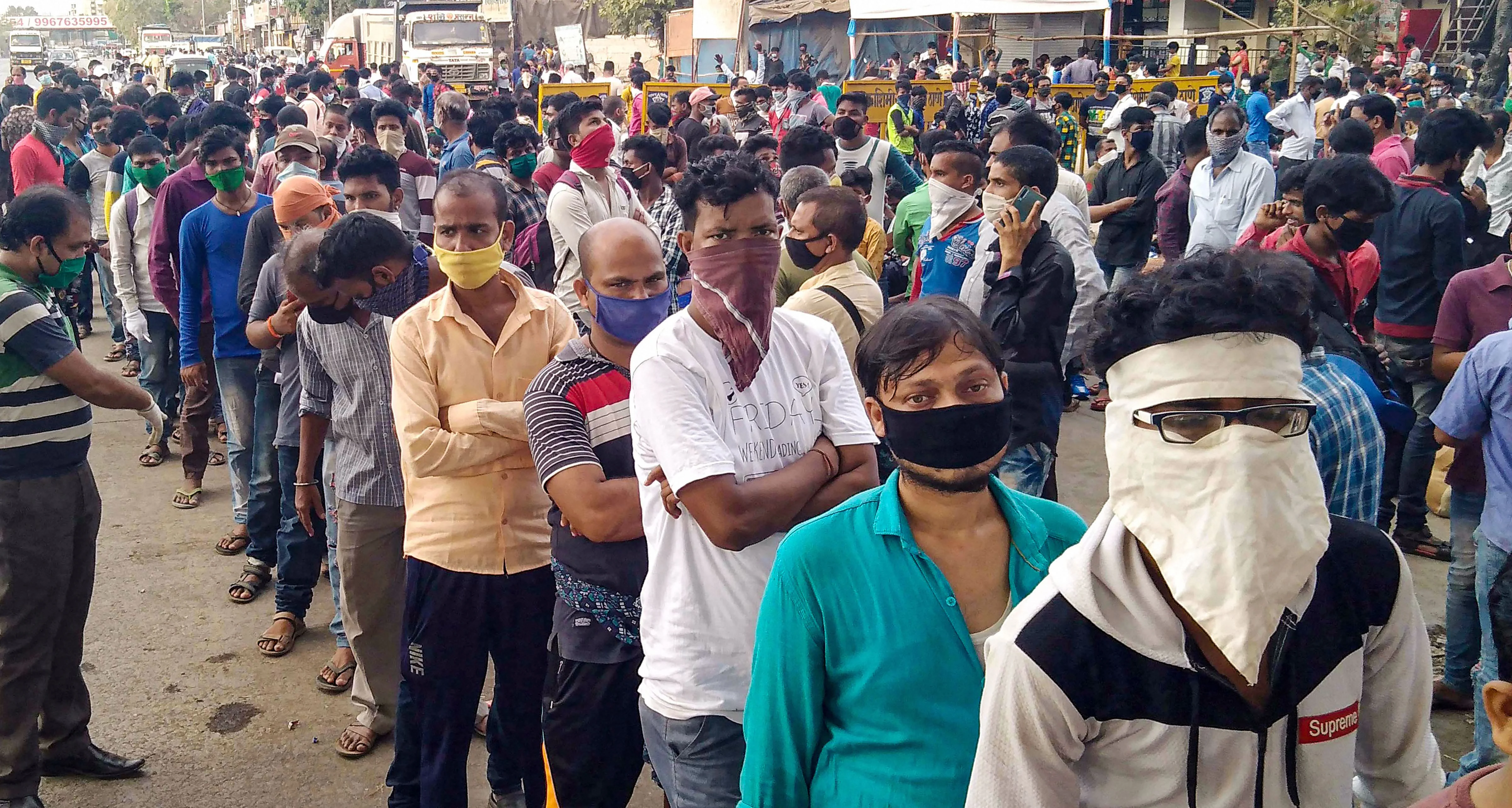 Long way home: Migrants queue for train tickets at Mumbai